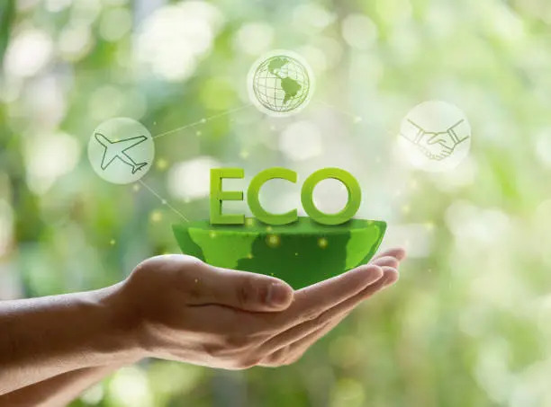 Hands-cupping-a-green-half-globe-with-large-floating-green-letters-that-spell-ECO-with-icons-for-a-plane-globe-and-handshake-representing-sustainability-and-green-business